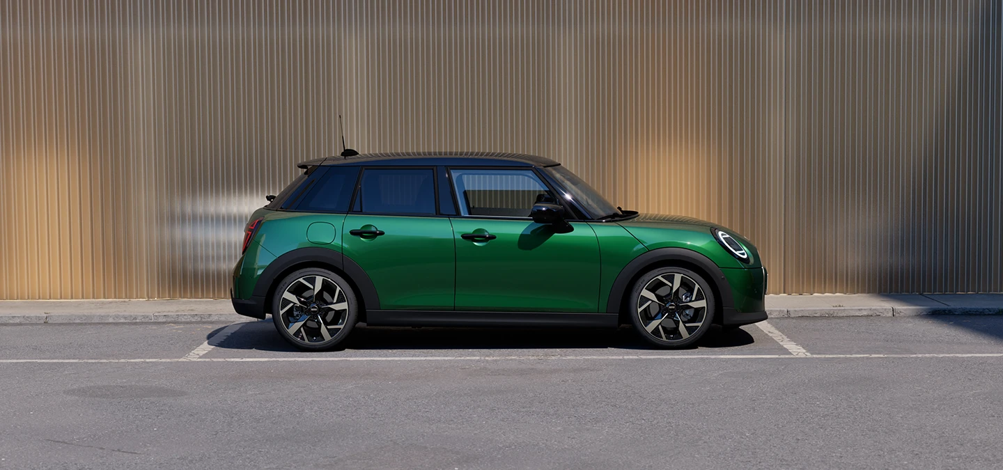 Sivukuva British Racing Green -värisestä ja mustakattoisesta 5-ovisesta MINI Cooperista pysäköitynä.