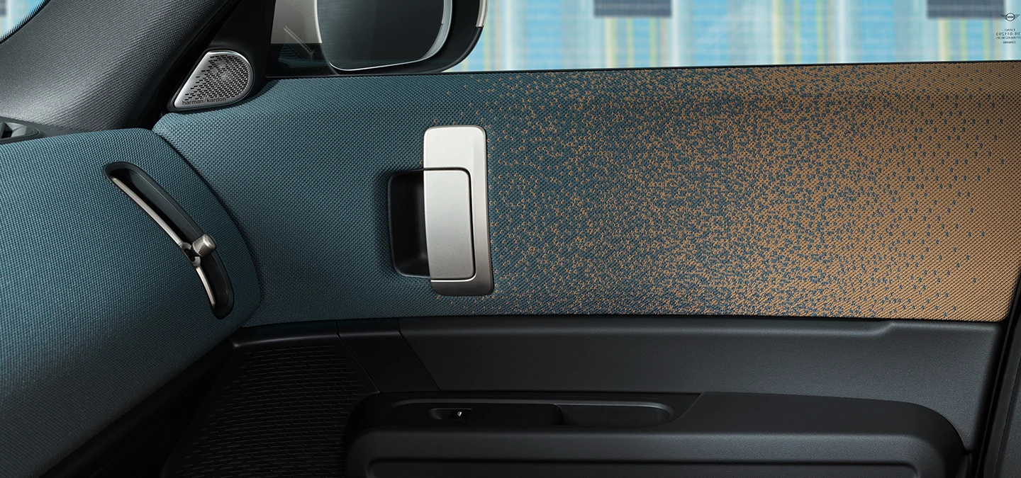 Lähikuva täyssähköisen MINI Countrymanin sisustusmuotoilusta, jossa keskiössä ovi ja kojelauta.