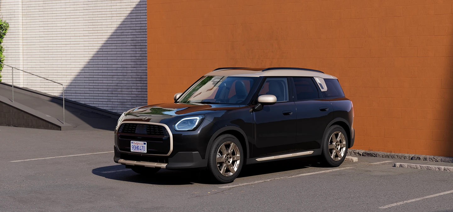 Sivukuva edestä MINI Countrymanista Midnight Black -värissä ja Vibrant Silver -katolla, pysäköitynä.