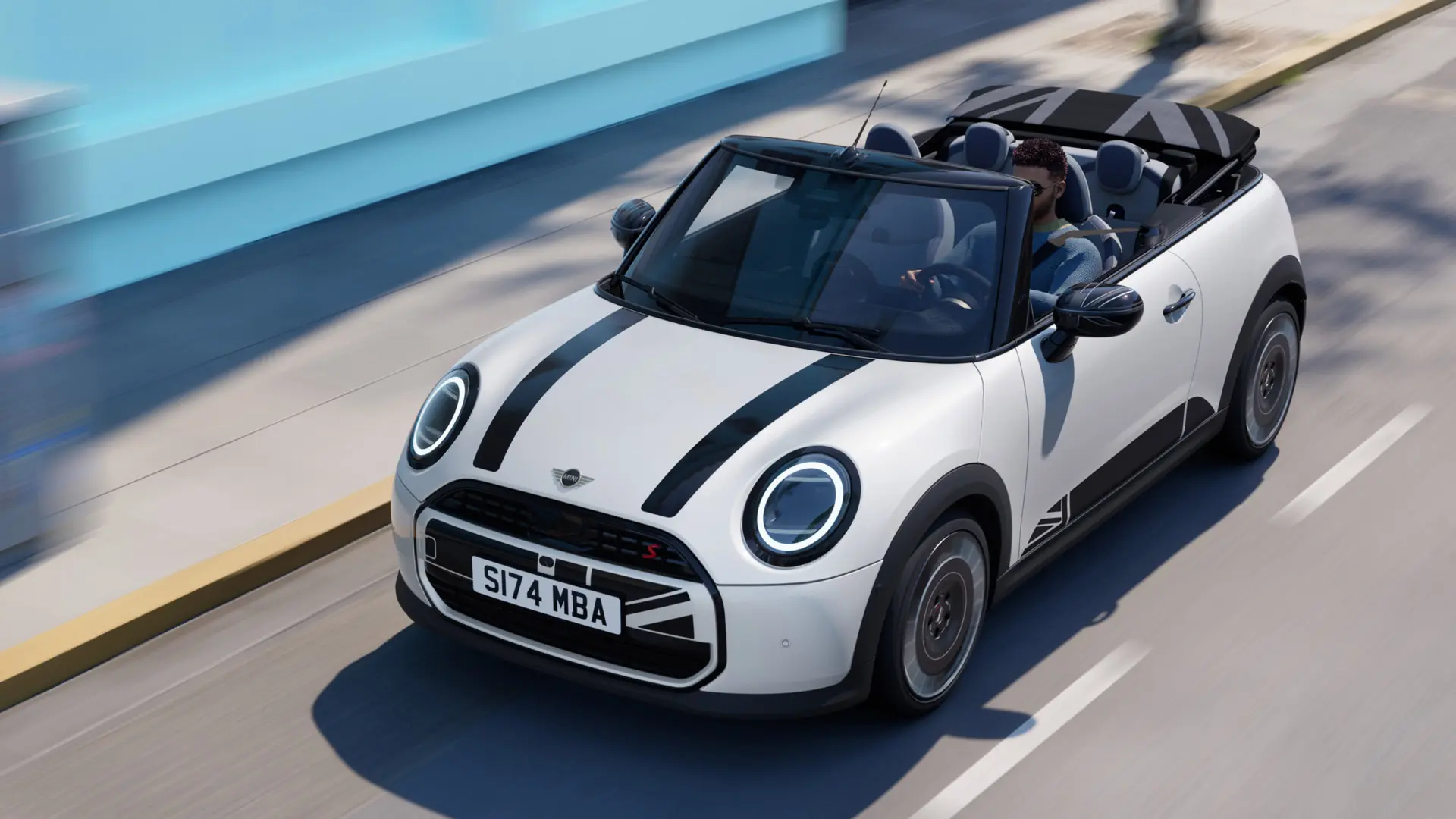 Yläkuva Nanuq White -värisestä MINI-avoautosta, jossa on mustat MINI Heritage -konepellitarrat. 