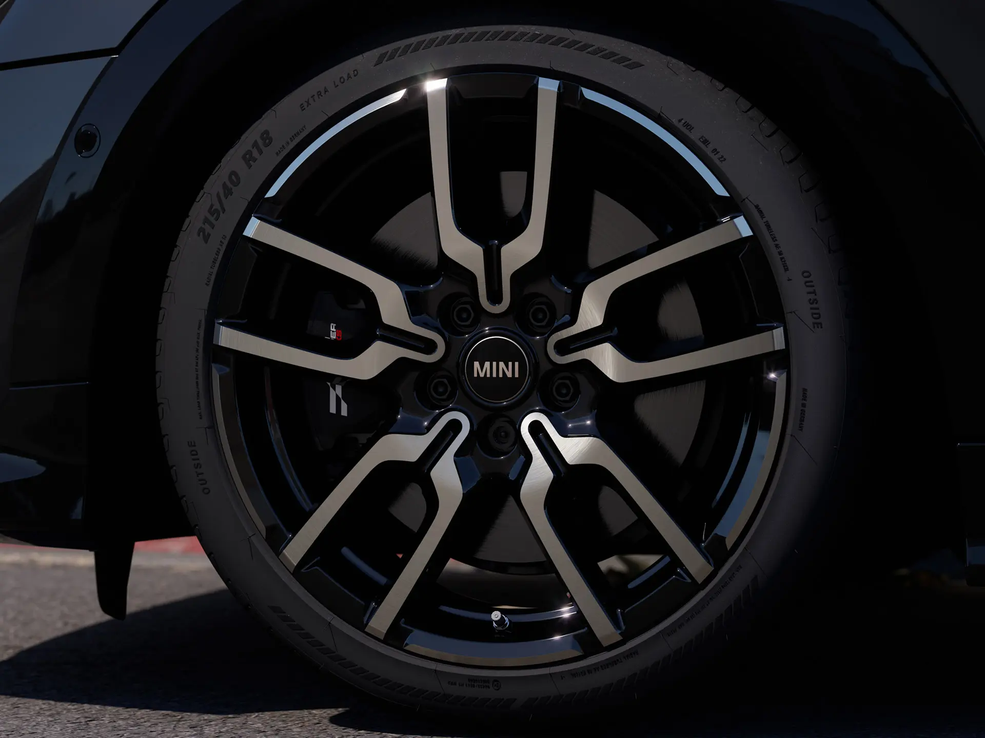 Lähikuva JCW Lap Spoke ‑kevytmetallivanteesta, jossa näkyy sen erottuva avoimen puolan muotoilurakenne Jet Black ‑viimeistelyllä. 