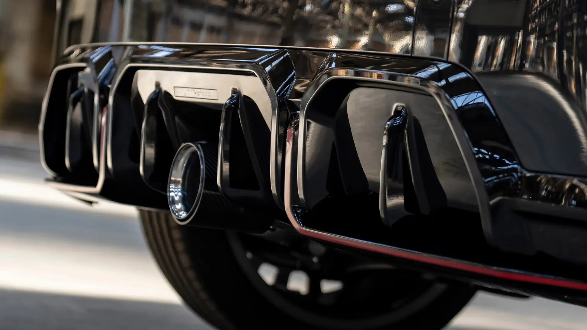 MINI John Cooper Works ‑takadiffuusori kiiltävän mustana punaisella kehyksellä.