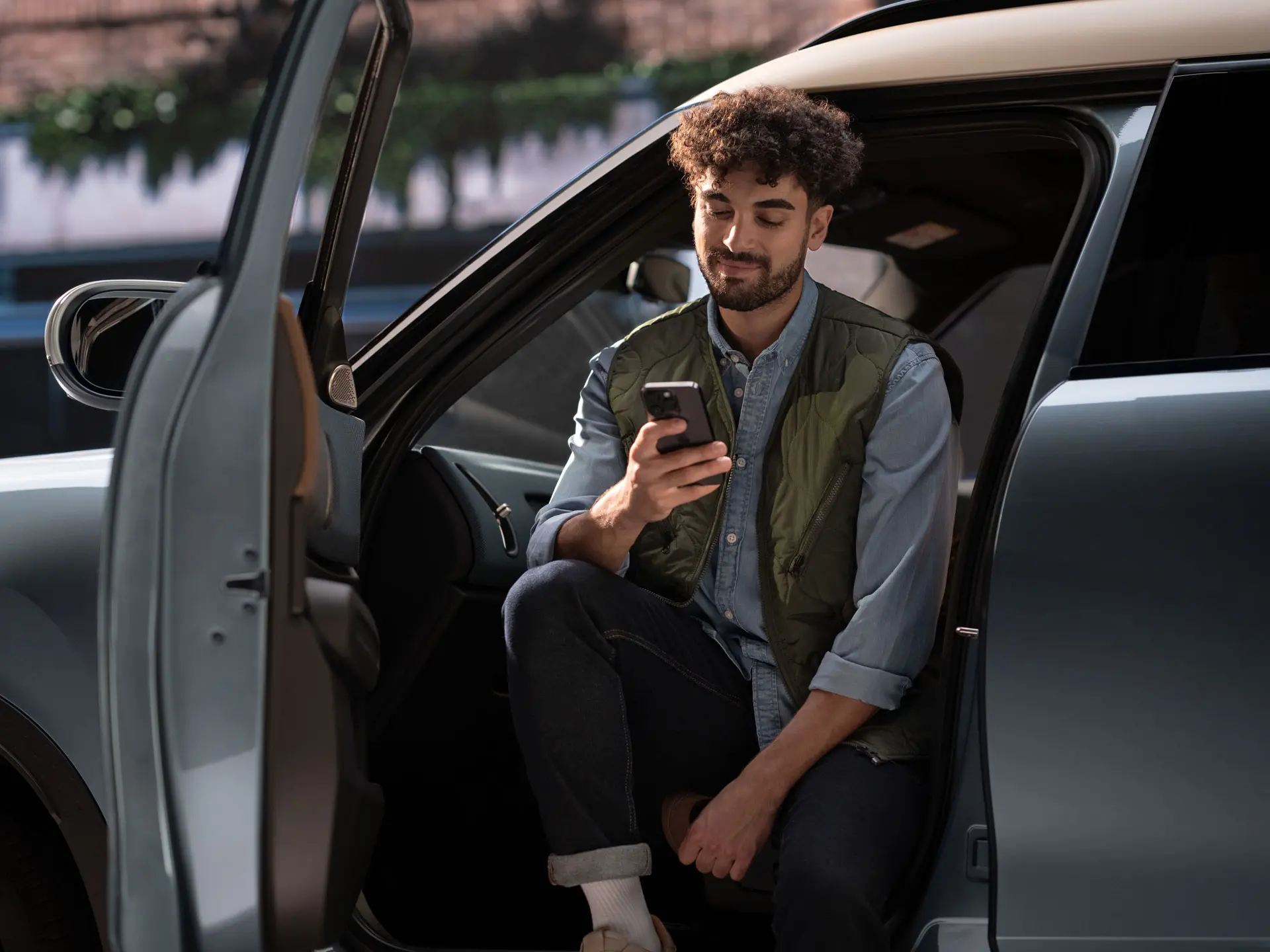 Mies varaa huoltoon ajan käyttäen matkapuhelintaan.