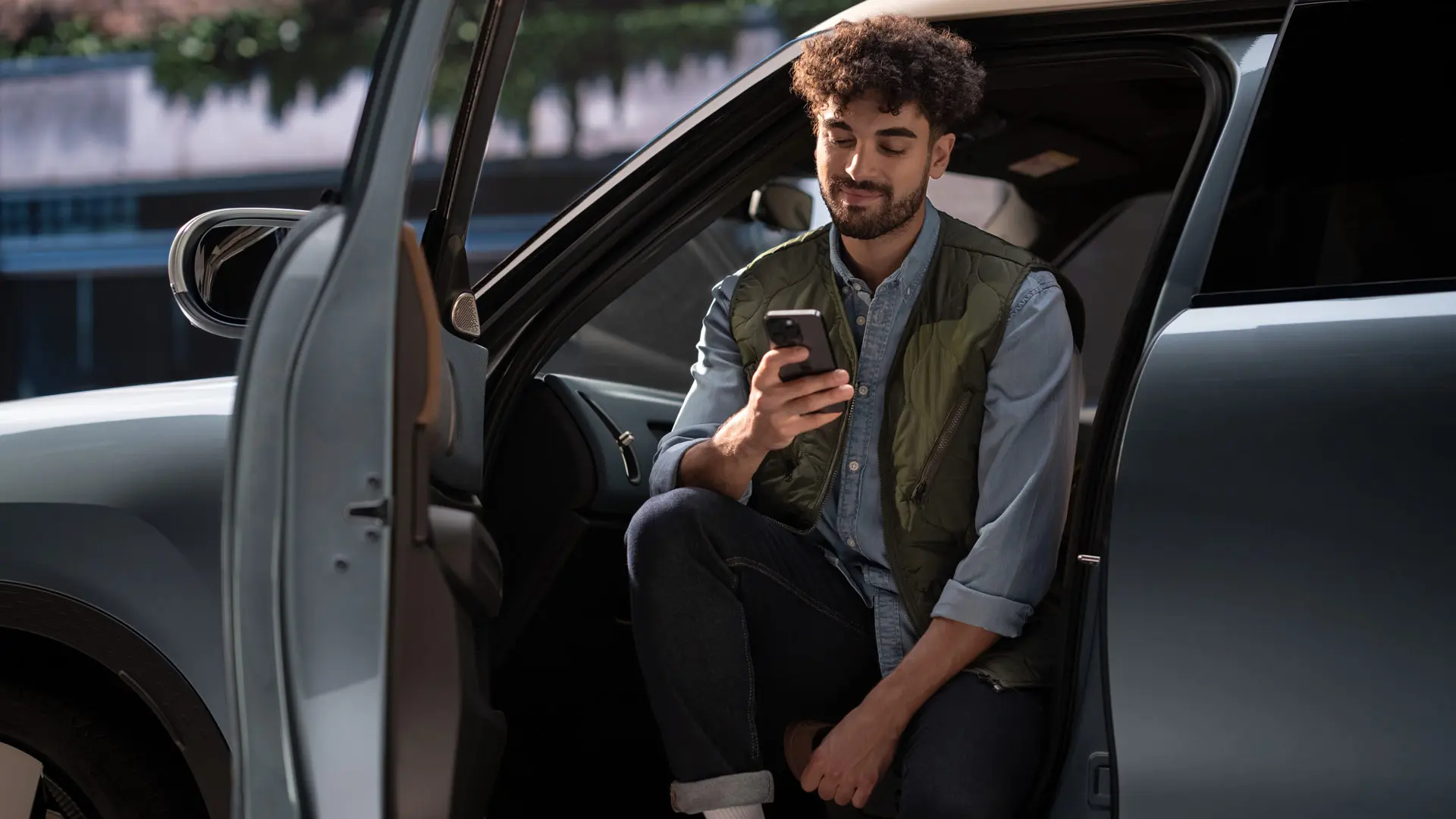 Mies varaa huoltoon ajan käyttäen matkapuhelintaan.