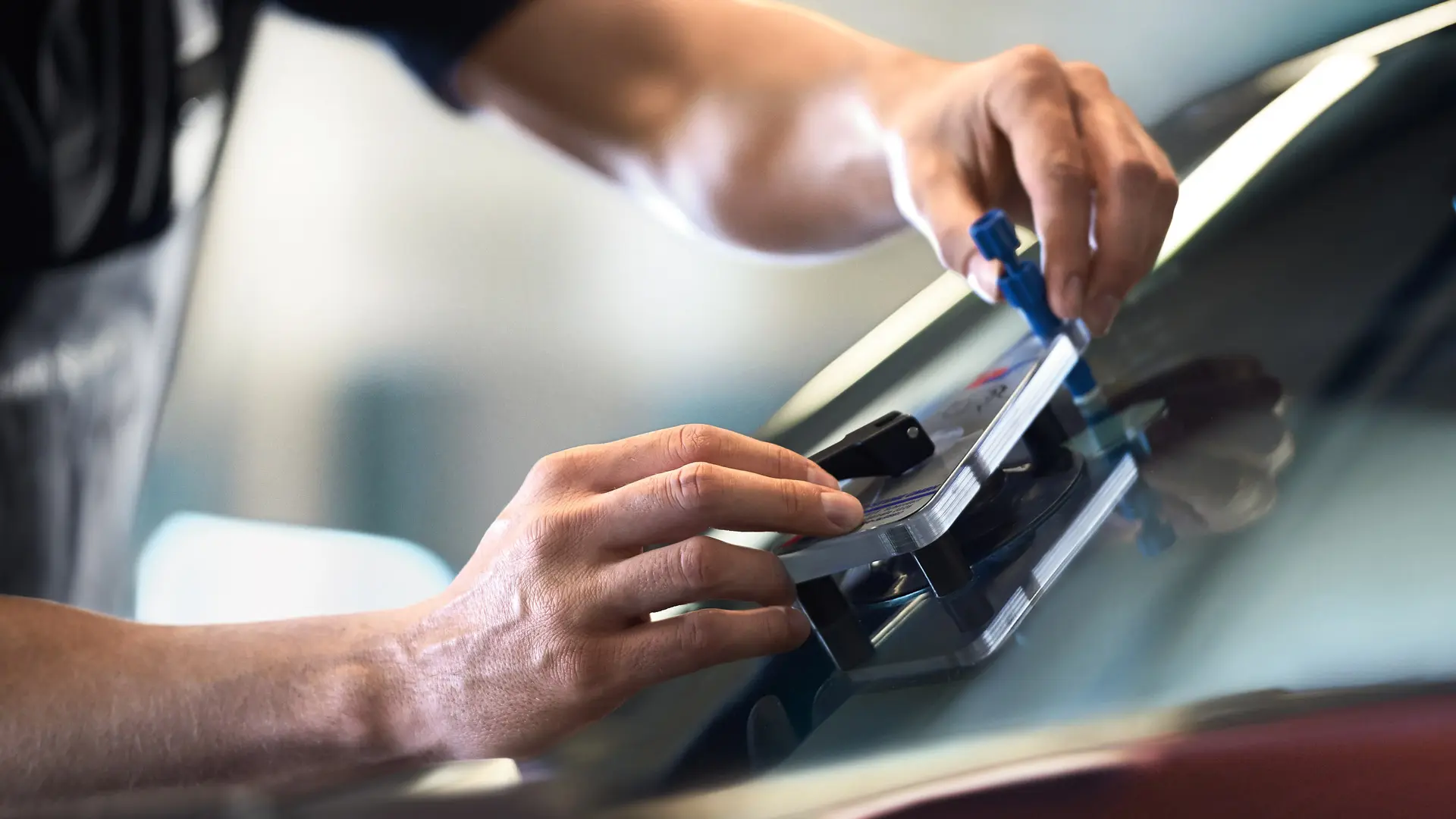 MINIn työntekijä korjaa lasia