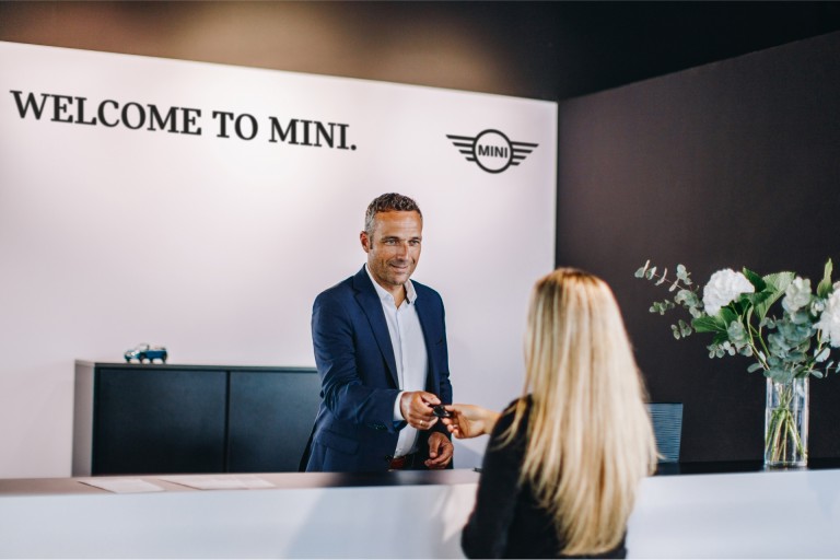 MINI Partnerin tervetulopöytä sekä työntekijä ja asiakas