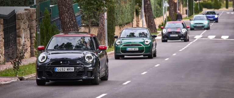 Ryhmä MINI-autoja ajaa jonossa luonnonkauniilla tiellä